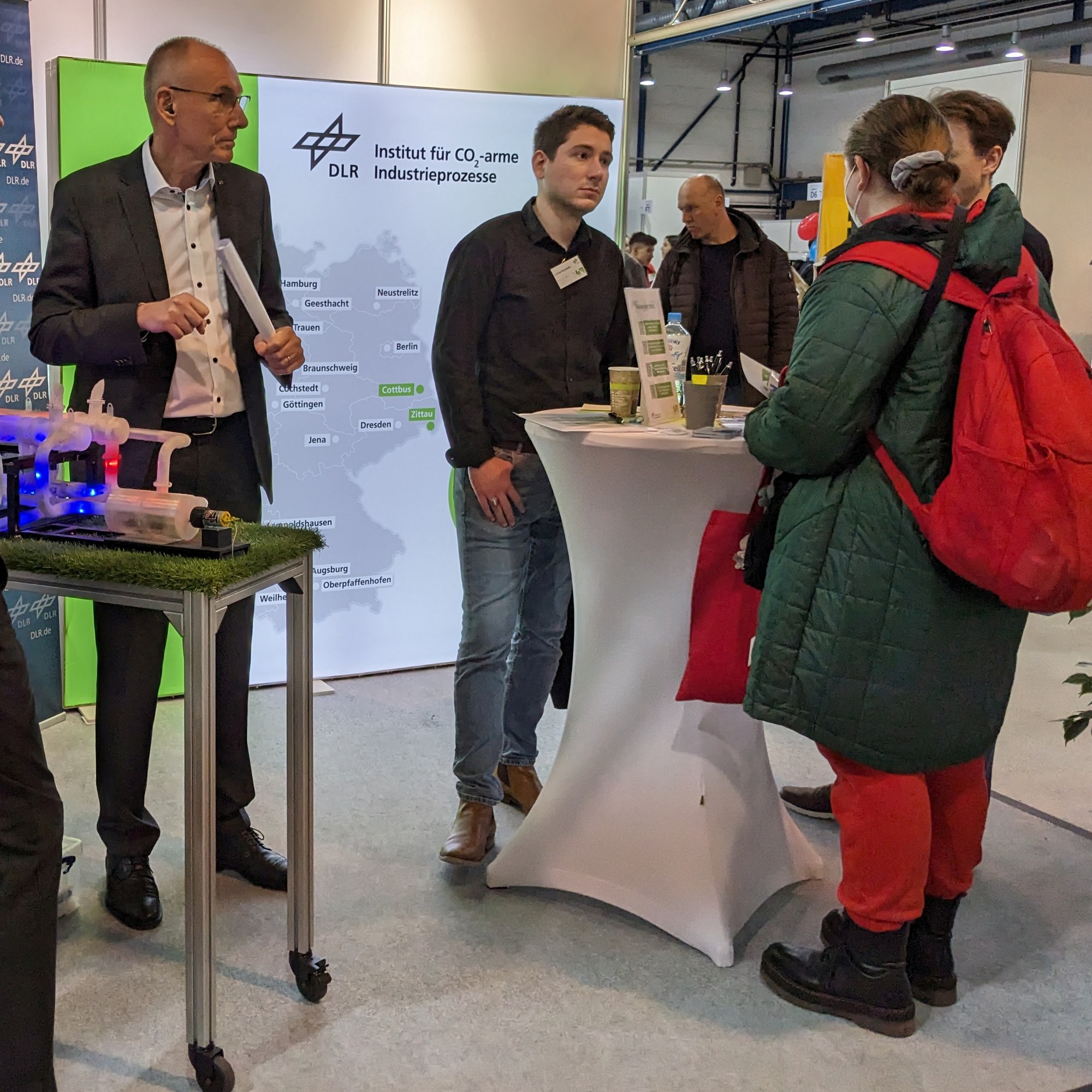 DLR-Mitarbeitende im Gespräch mit Interessierten auf einer Messe.