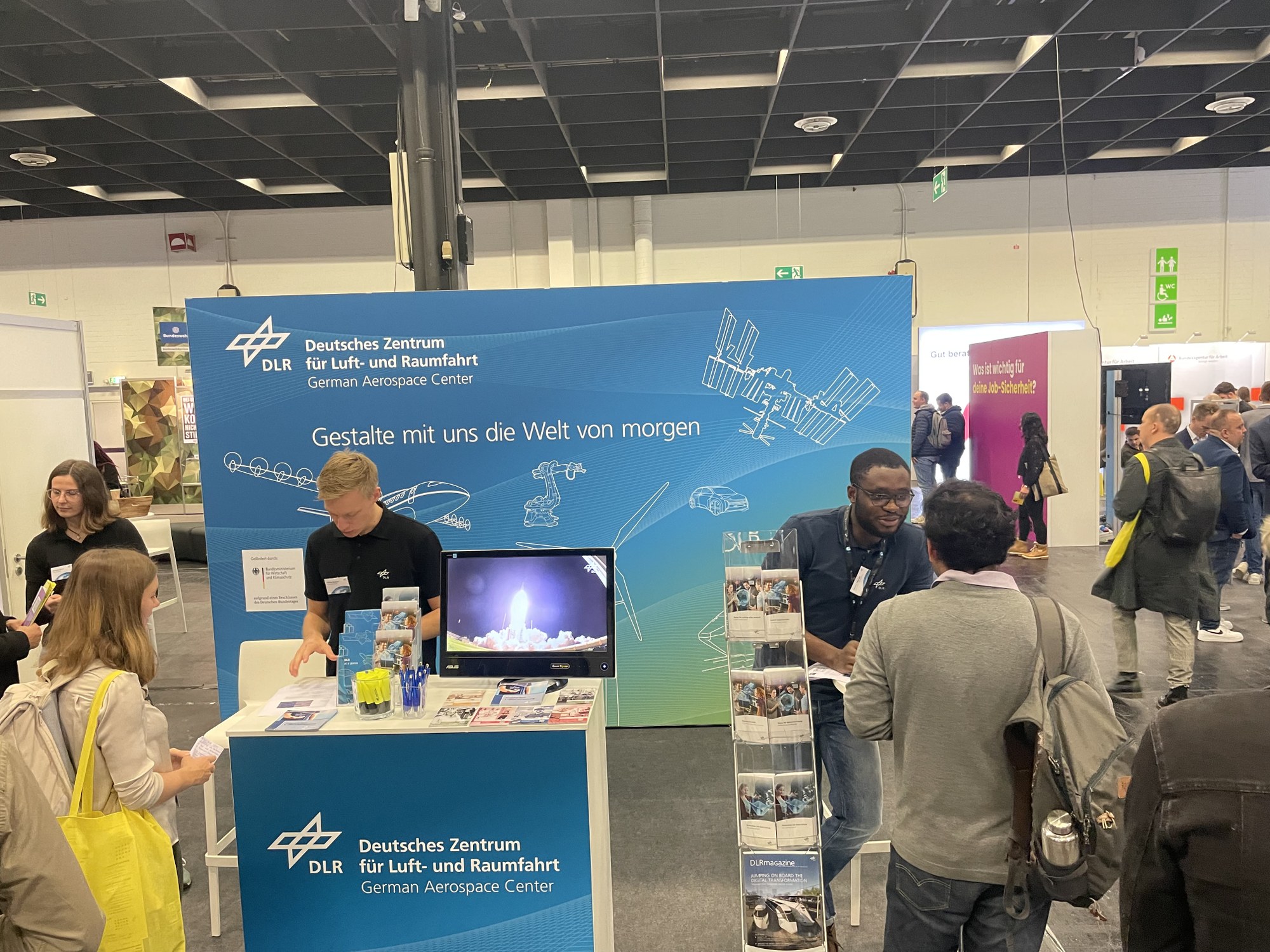 DLR-Mitarbeitende im Gespräch mit Interessierten auf einer Karrieremesse.