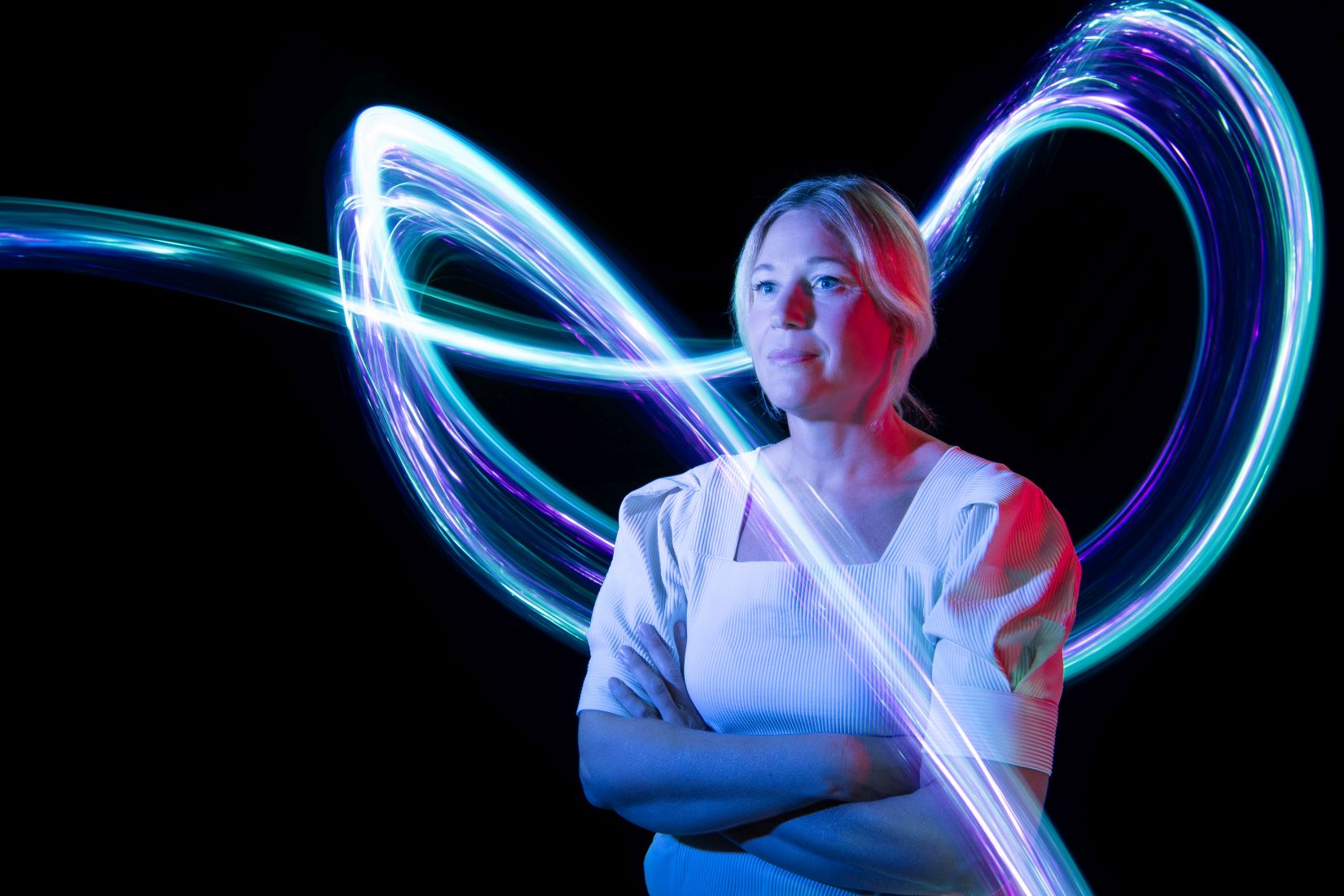 Das Bild zeigt DLR-Mitarbeiterin Birgit und leuchtende Lichtspuren