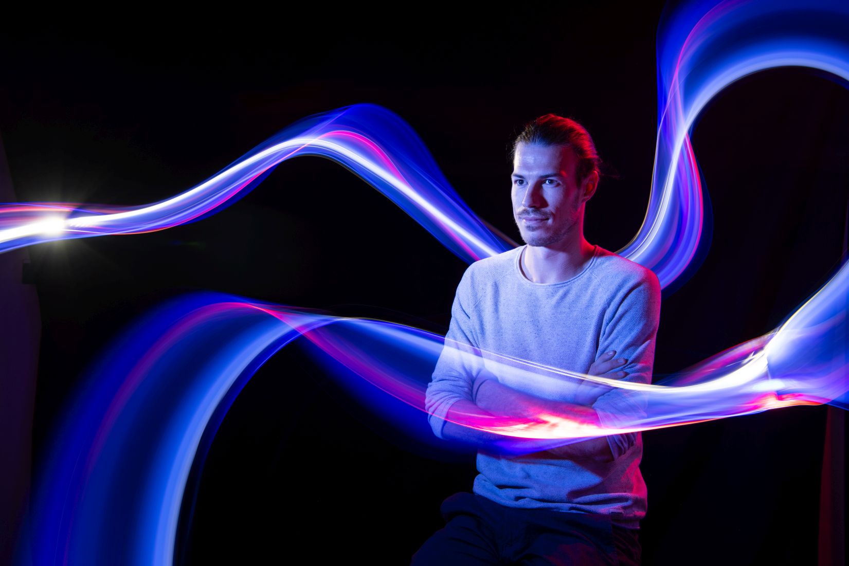 Das Bild zeigt DLR-Mitarbeiterin Tobias und leuchtende Lichtspuren