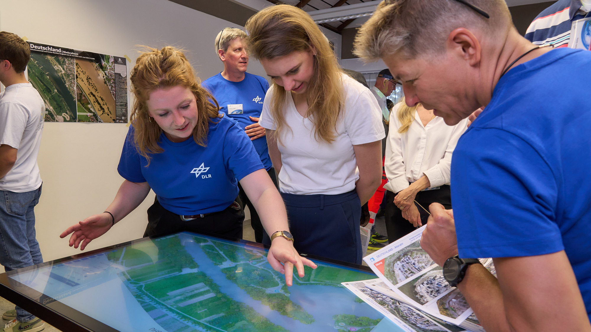 Mehrere Menschen betrachten eine interaktive 3D-Lagedarstellung.