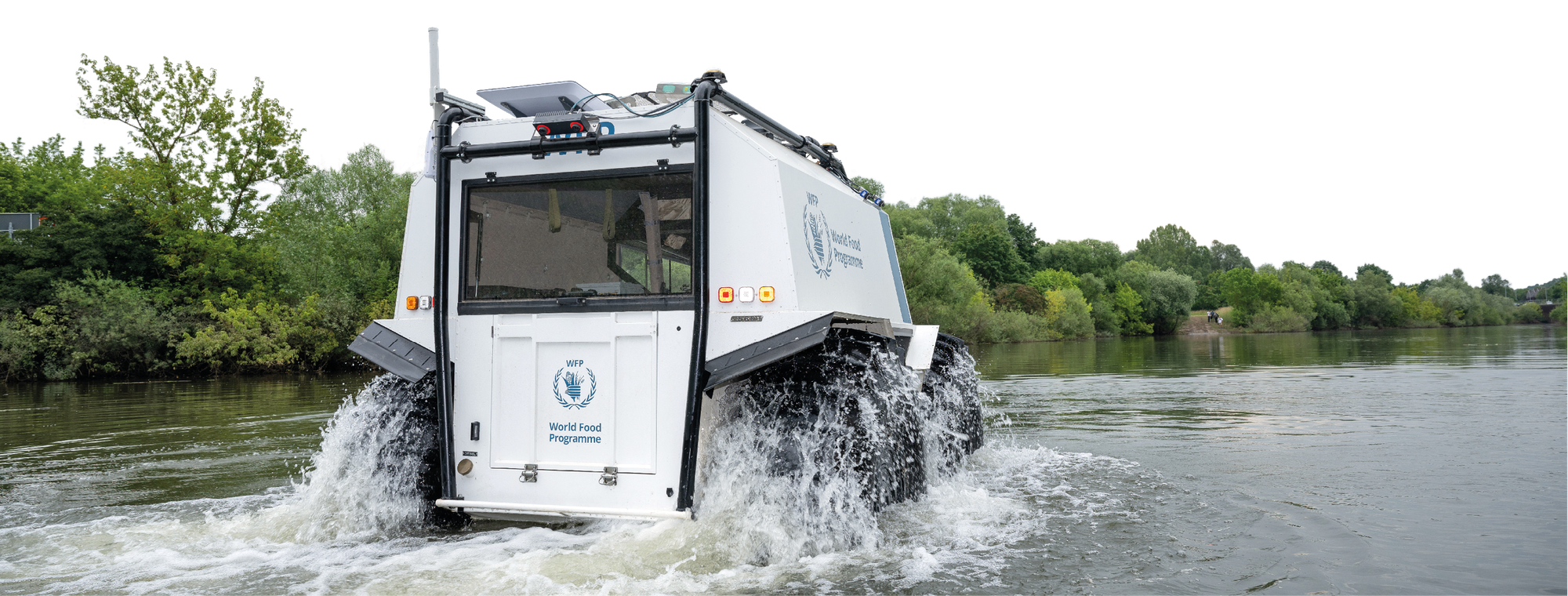 Foto des Amphibienfahrzeugs SHERP von hinten. Man sieht, wie es durchs Wasser fährt.