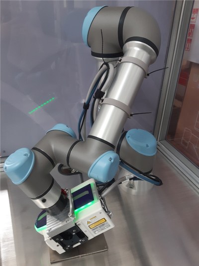Ein Roboterarm in einem Glaskasten, der ein Messgerät führt.