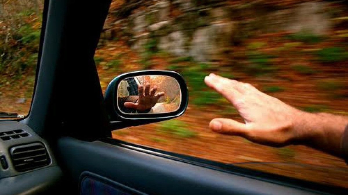 Mann hält Hand aus dem Auto