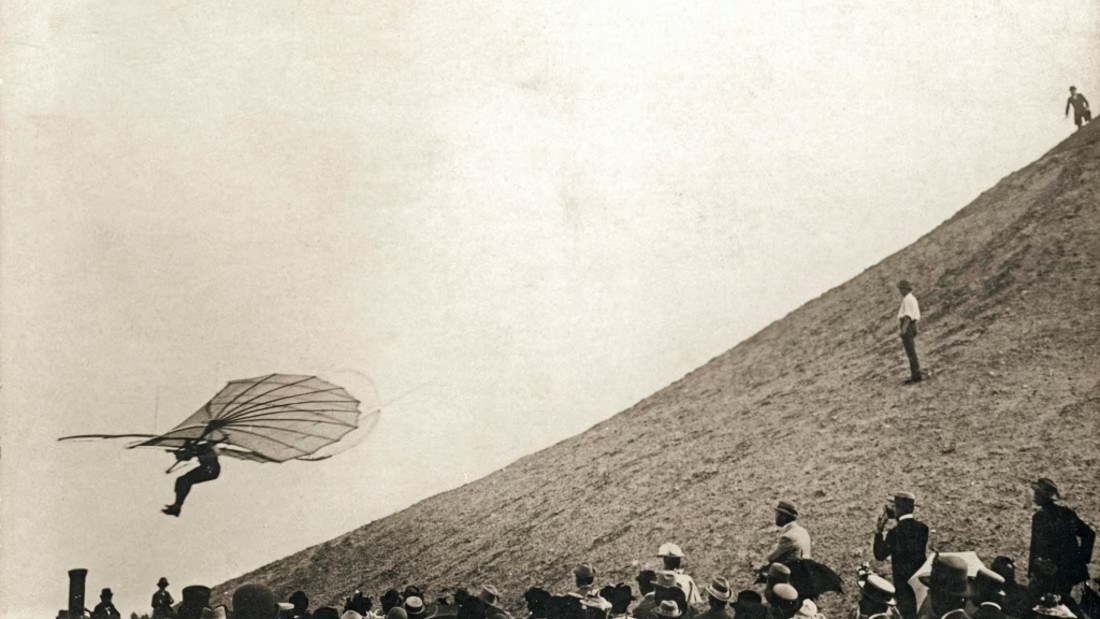 Das Bild zeigt Otto Lilienthal, wie er mit einem selbst gebauten Fluggerät durch die Luft segelt.