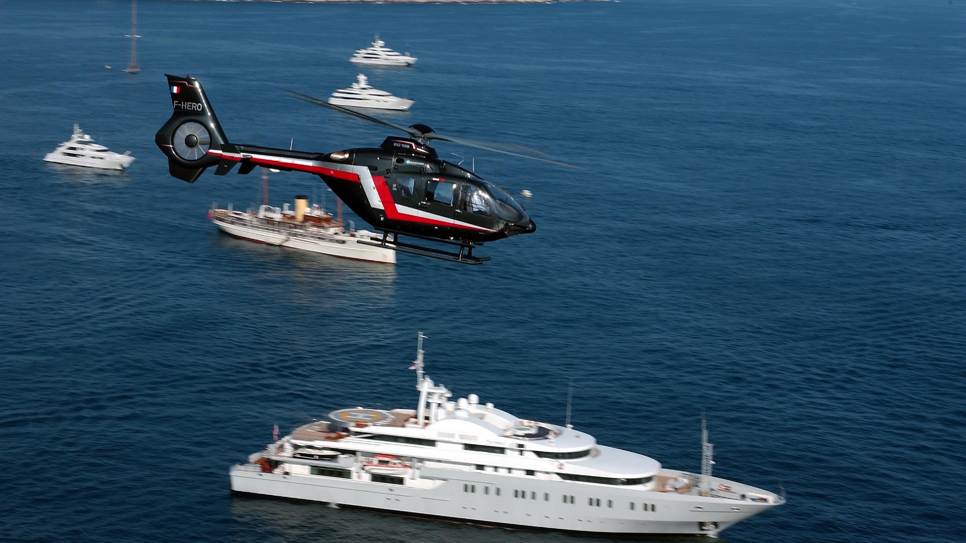 Hubschrauber mit Yacht im Hintergrund