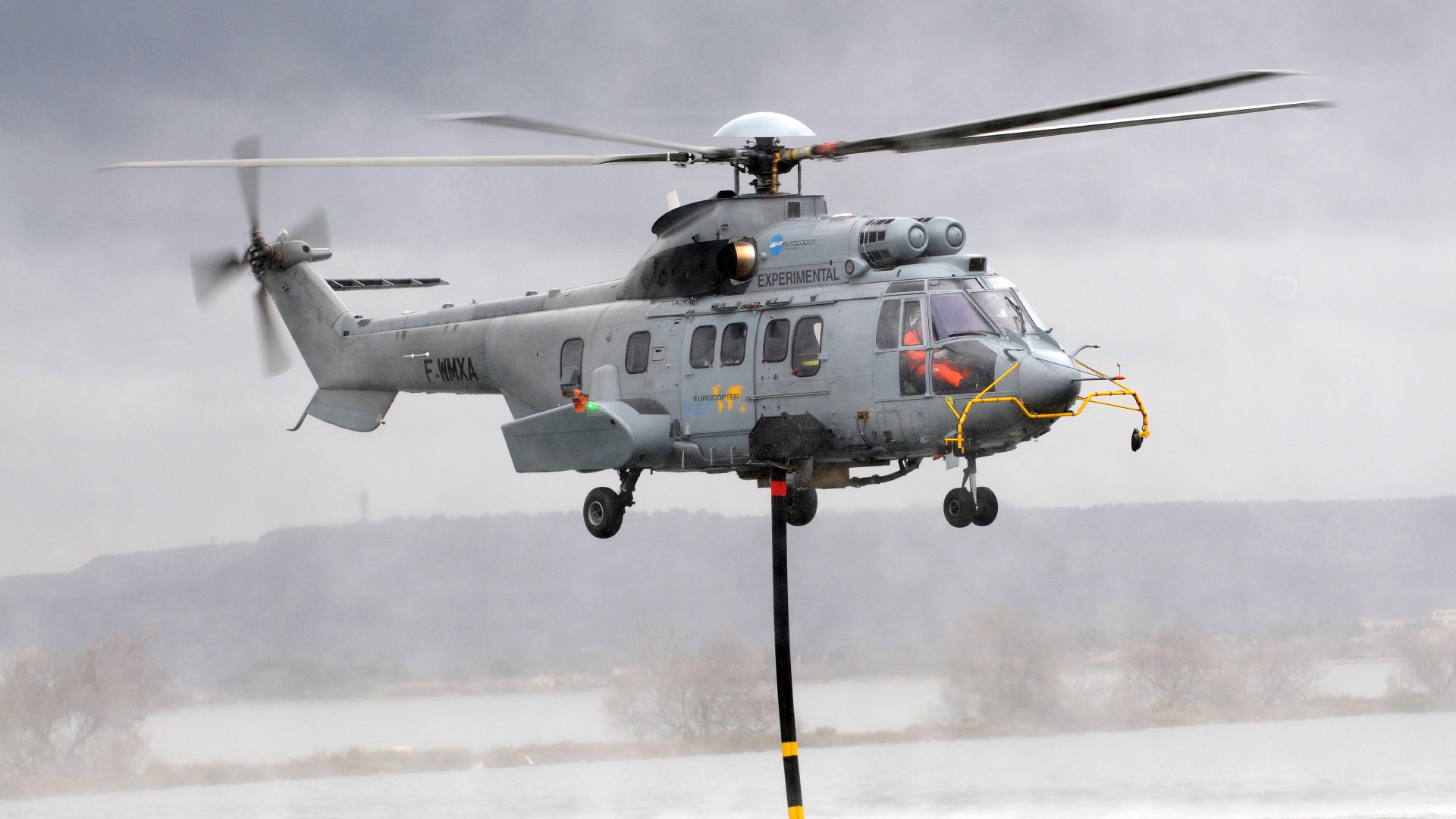 Hier nimmt ein Hubschrauber Löschwasser in einem See auf.