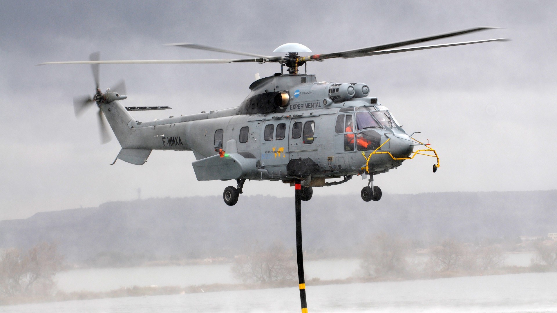 Hier nimmt ein Hubschrauber Löschwasser in einem See auf.