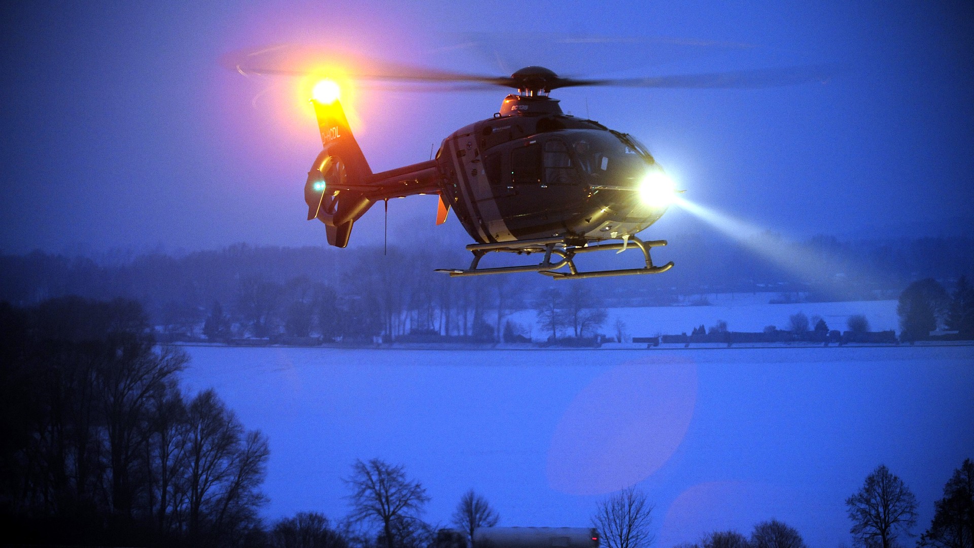 Hubschrauber in der Dunkelheit mit Suchscheinwerfer.