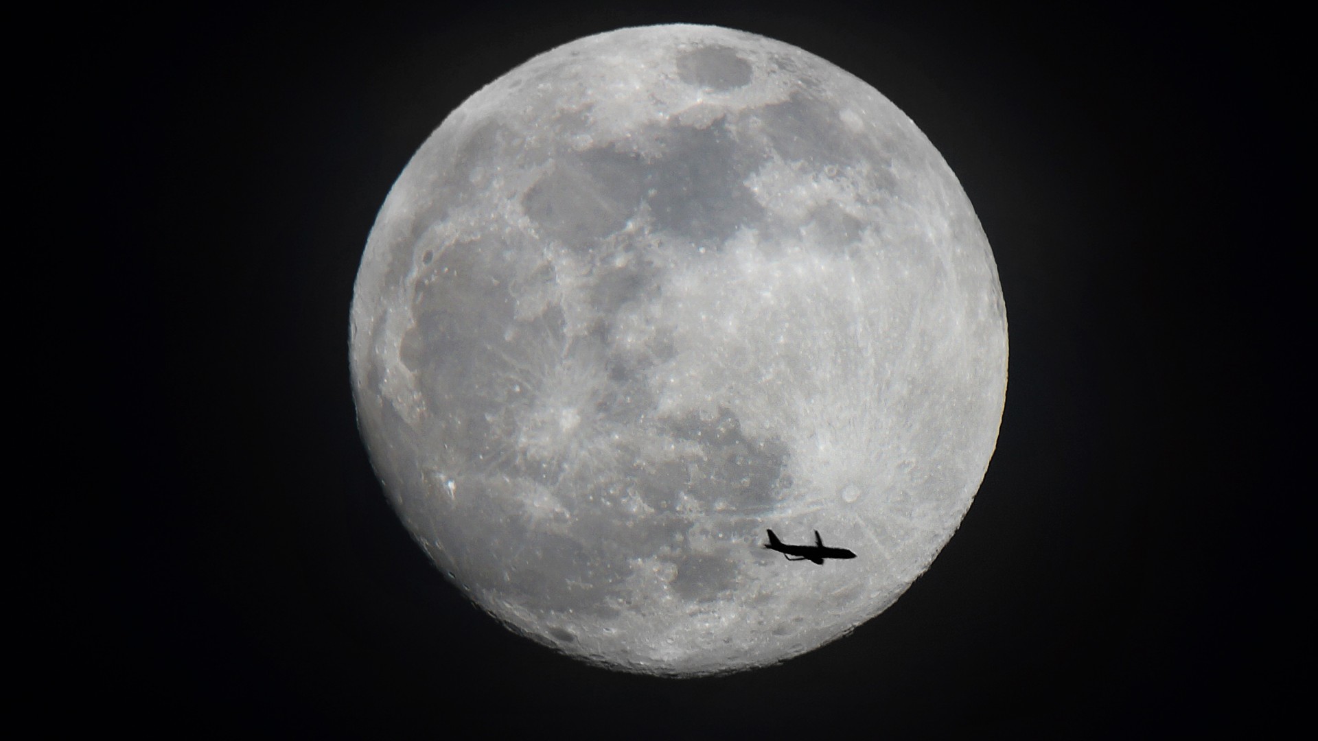 Flugzeug, im Hintergrund ist der Mond zu sehen