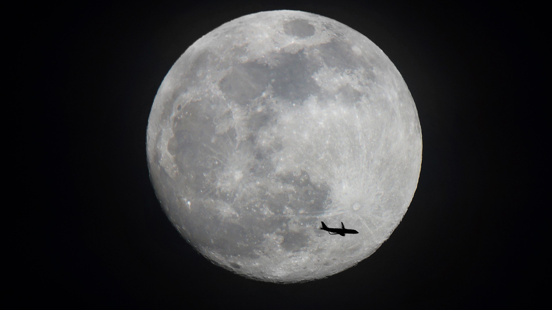 Flugzeug, im Hintergrund ist der Mond zu sehen