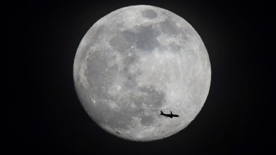 Flugzeug, im Hintergrund ist der Mond zu sehen