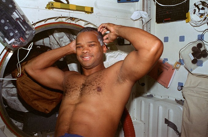 Robert L. Curbeam wäscht sich mit Trocken-Shampoo die Haare. Anders als auf der Erde kann man hier keine Dusche benutzen, da die Wassertropfen durch die Luft schweben würden. Versuche, auf Raumstationen eine Dusche einzurichten, sind bisher nicht zufriedenstellend gelungen. Die morgendliche Körperpflege funktioniert mit nassen Handtüchern – denn Hygiene ist natürlich besonders wichtig, zumal das Immunsystem in Schwerelosigkeit weniger leistungsfähig ist.
