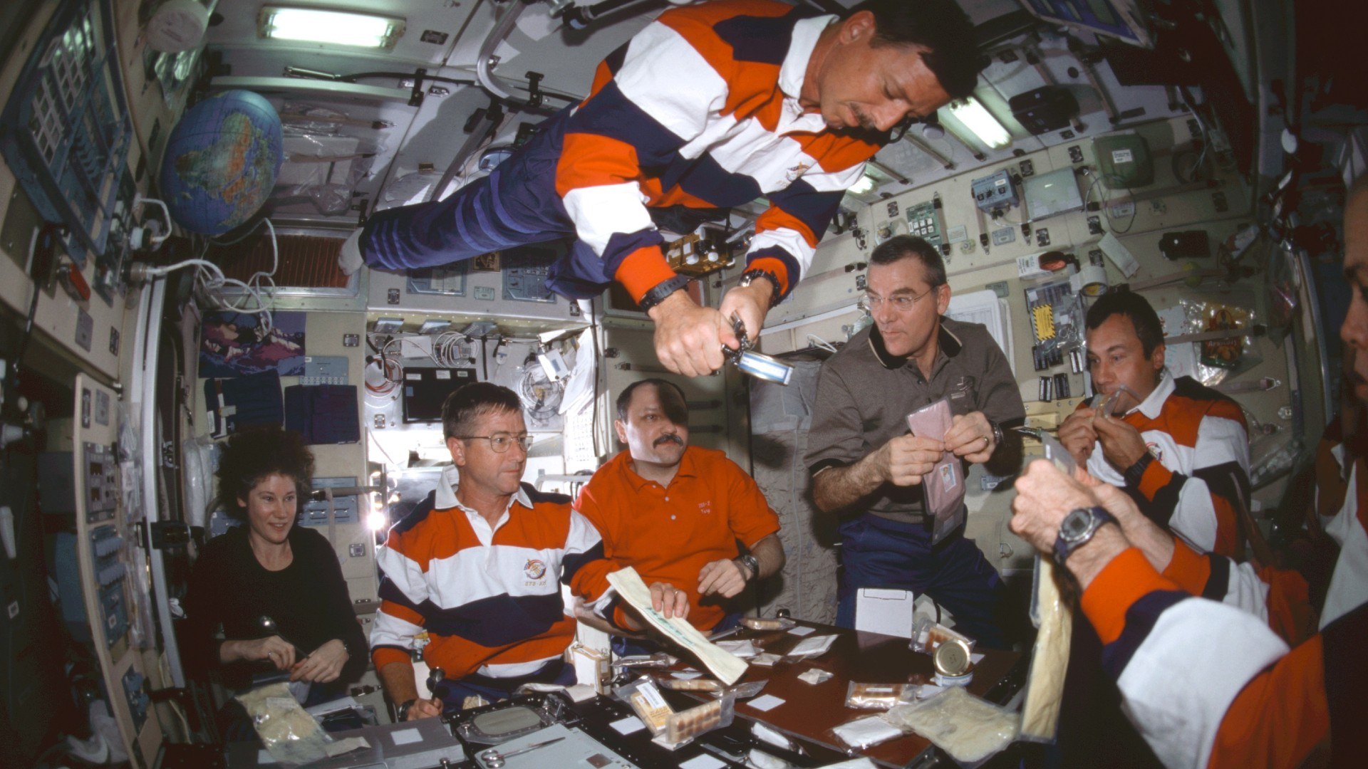 Sechs Astronauten und eine Astronautin beim Essen