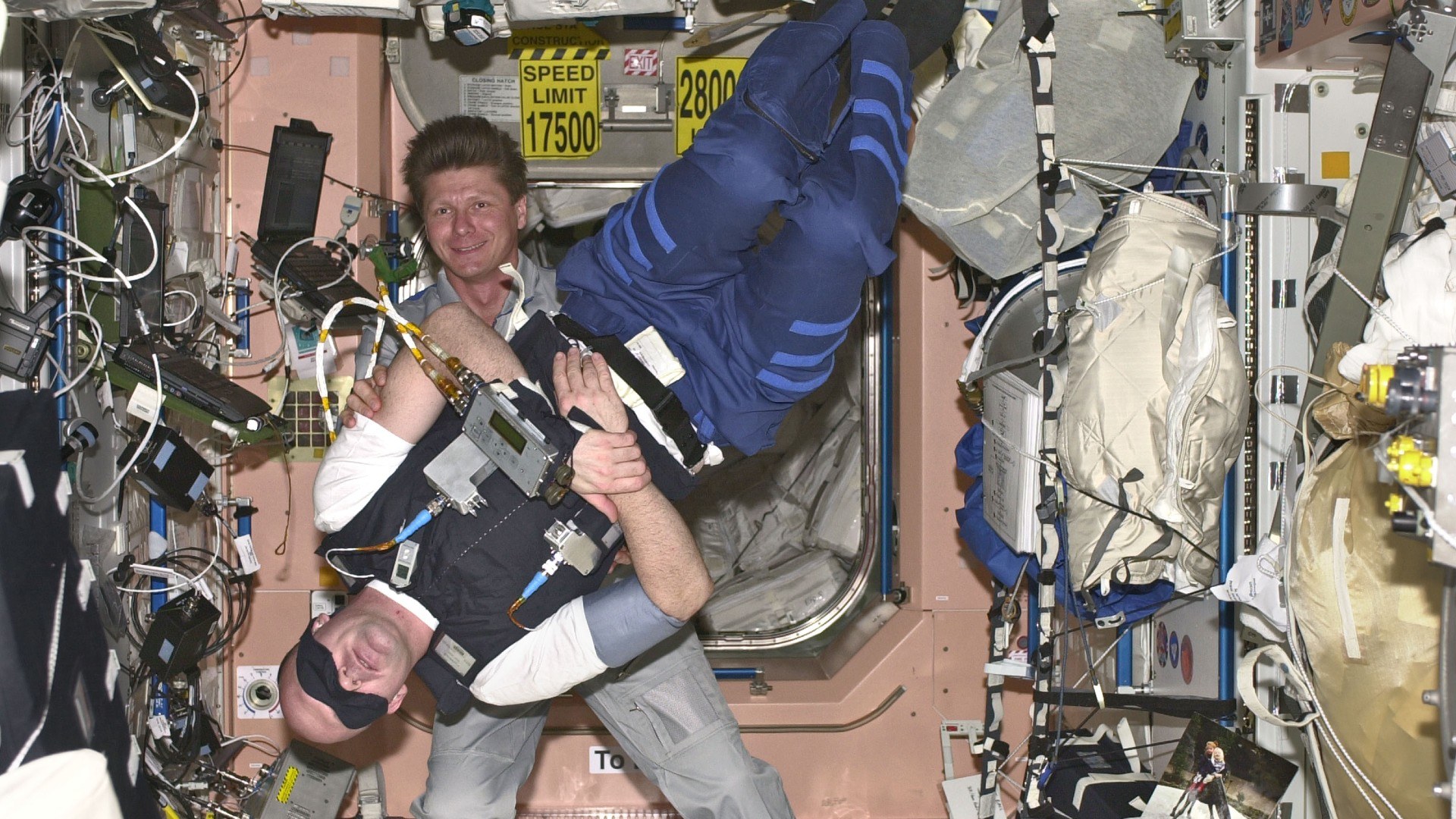 Gennady Padalka aus Russland (im Hintergrund) hilft ESA-Astronaut André Kuipers aus den Niederlanden bei einem medizinischen Versuch. Es geht dabei um den Gleichgewichtssinn.