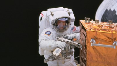 Weltraumspaziergänge sind harte Arbeit: Hier repariert Claude Nicollier aus der Schweiz einen Satelliten.