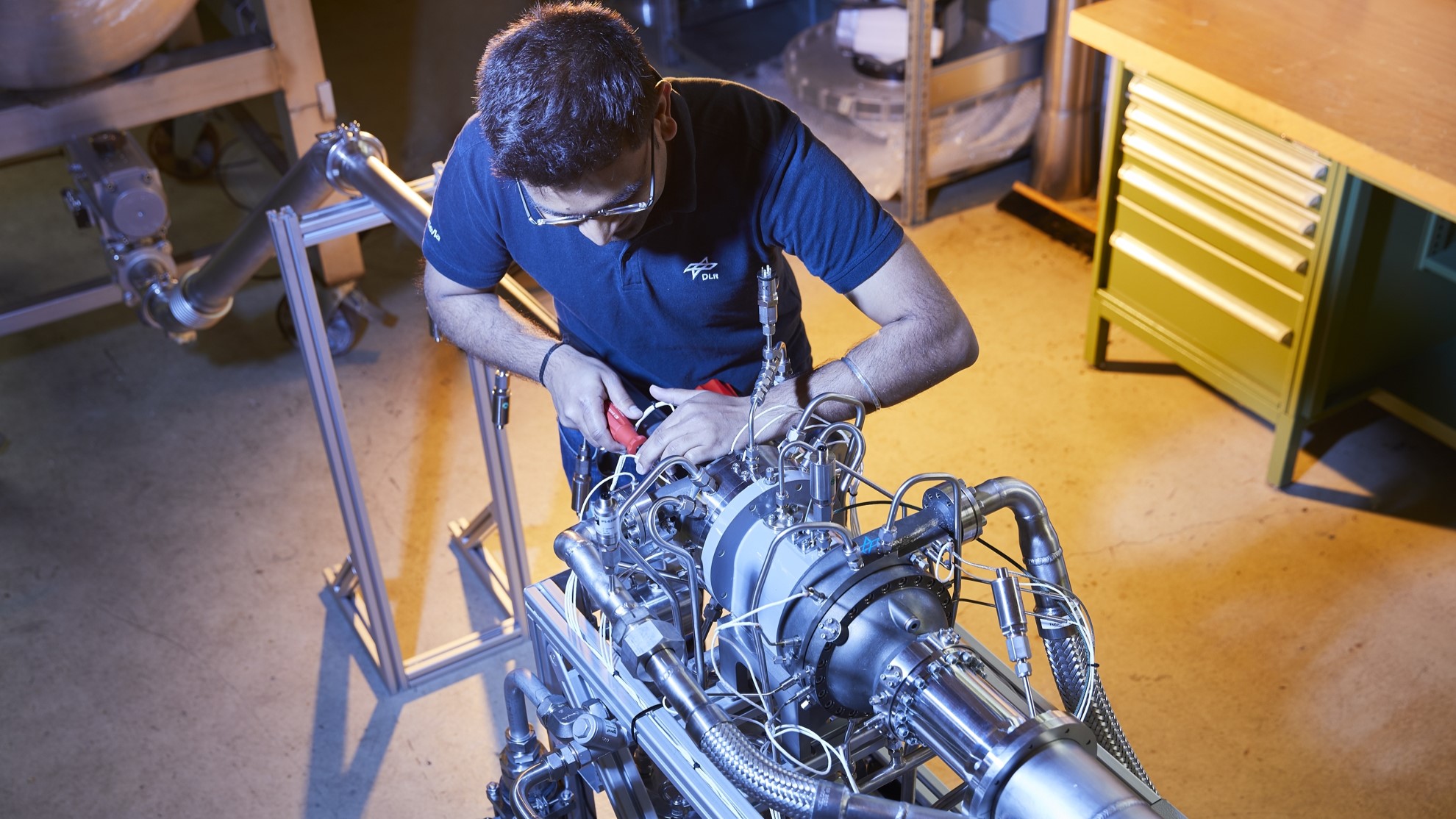 Das Bild zeigt einen DLR-Mitarbeitenden bei den letzten Justierungen der Turbopumpe am Prüfstand P6.2