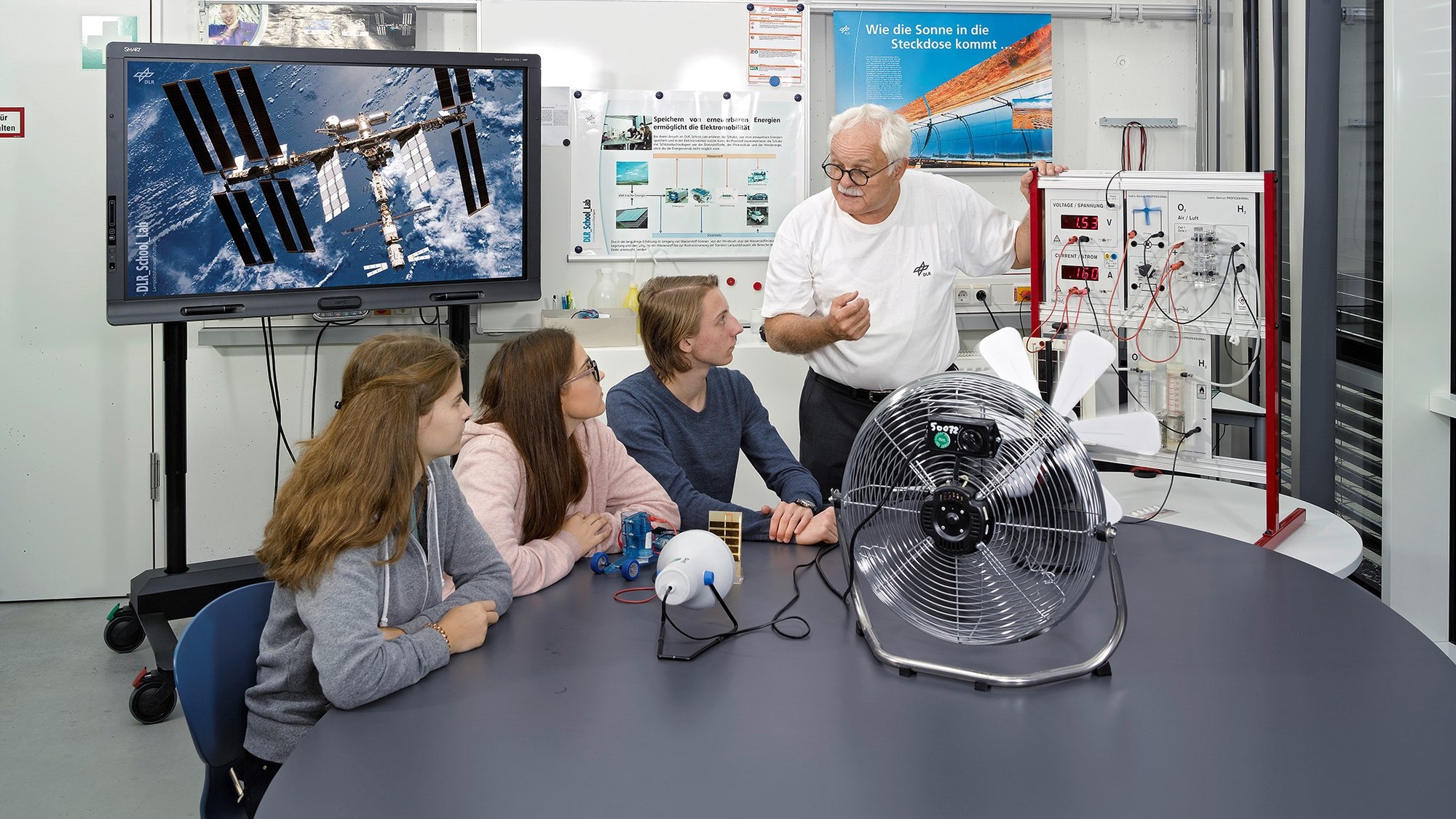 DAs Bild zeigt eine Gruppe Schüler beim Experimentieren.