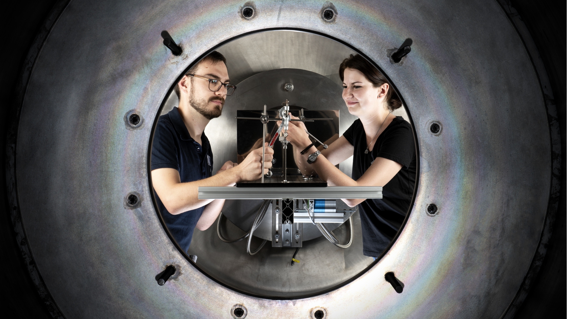 Das Bild zeigt zwei DLR-Mitarbeitende bei der Montage eines Forschungstriebwerks am Prüfstandskomplex M11.