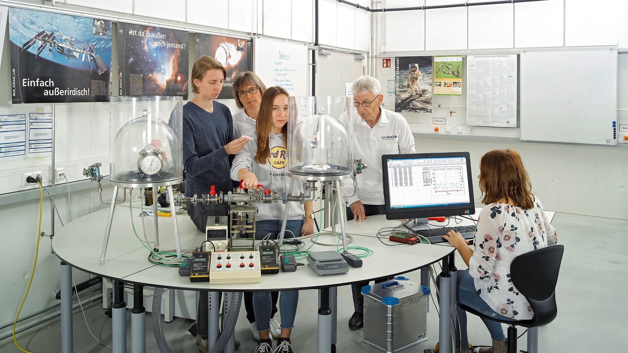 Das Bild zeigt einen Vakuumversuch mit einem Wecker.