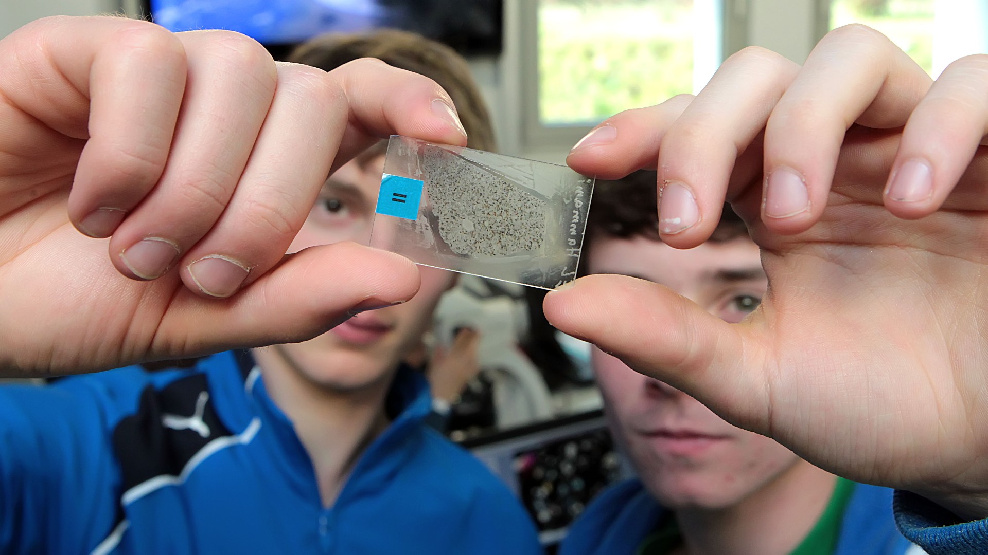 Nachwuchsforschende mit Meteoritscheibe in den Händen