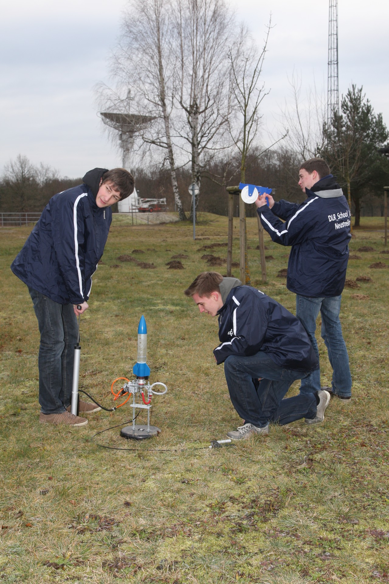 Schülergruppe bei Startvorbereitung für eine Wasserrakete.