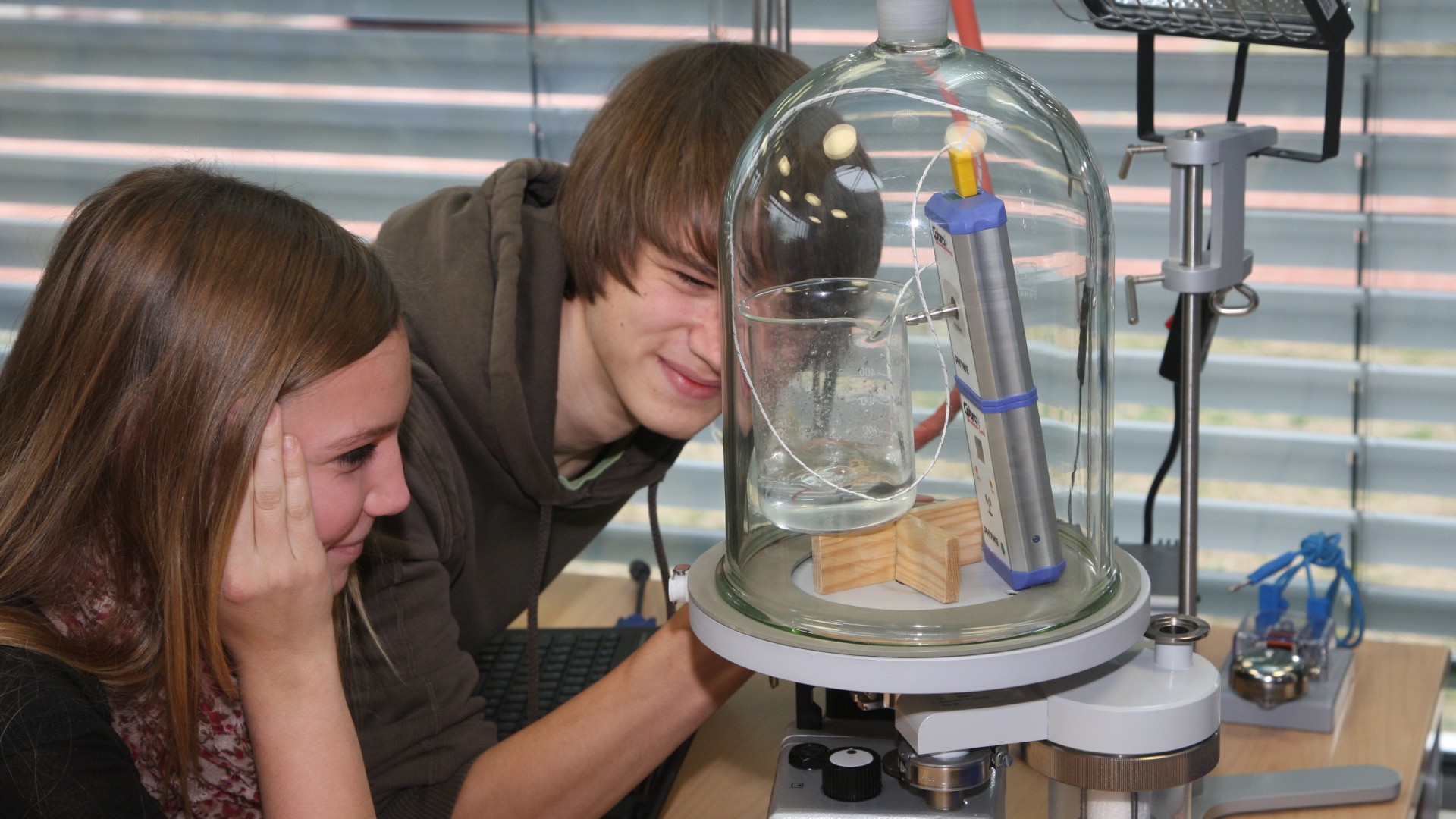 Nachwuchsforschende bei einem Experiment mit der Drehschieberpumpe