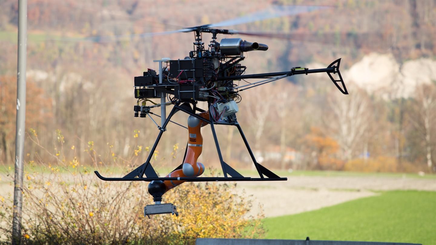 Ein autonomer Doppelrotor-Hubschrauber mit Roboterarm beim Flugversuch