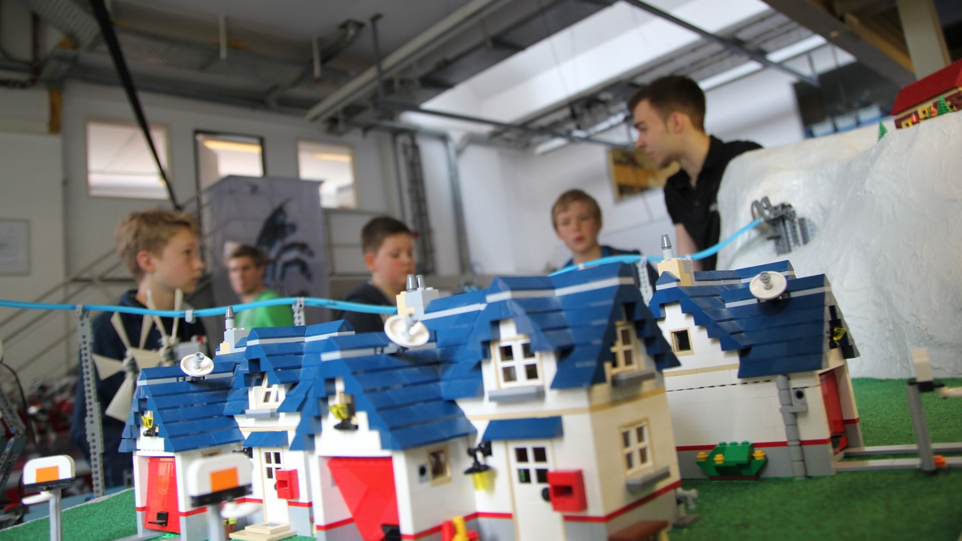Schülergruppe rund um eine Modellstadt aus Bausteinen