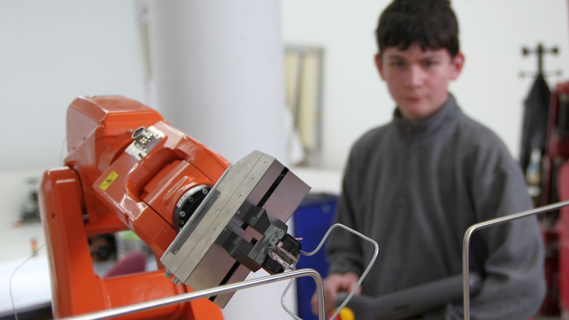 Schüler beim Experimentieren mit einem Roboter.