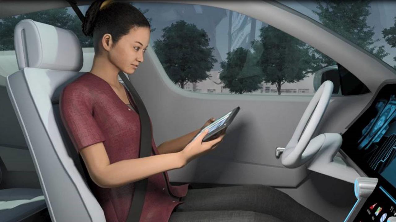 Zu sehen ist eine 3D-gerenderte Visualisierung einer weiblich gelesenen Person, welche in einem selbst-fahrenden Fahrzeug sich fortbewegt. Sie selbst interagiert unterdessen mit ihrem Smartphone