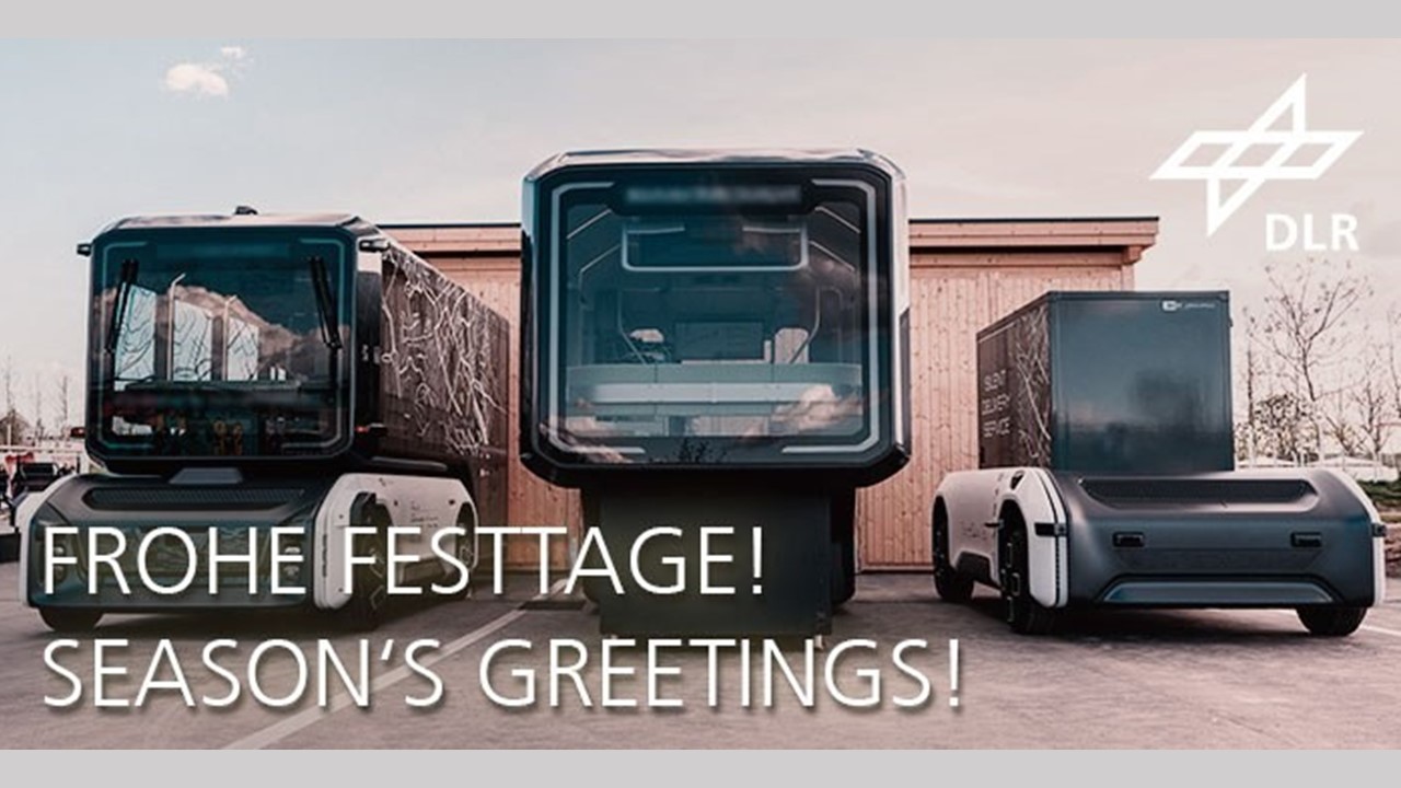 Zu sehen sind unterschiedliche Fahrzeugkonzepte des DLR. Das Foto ist beschriftet mit Feiertagsgrüßen.