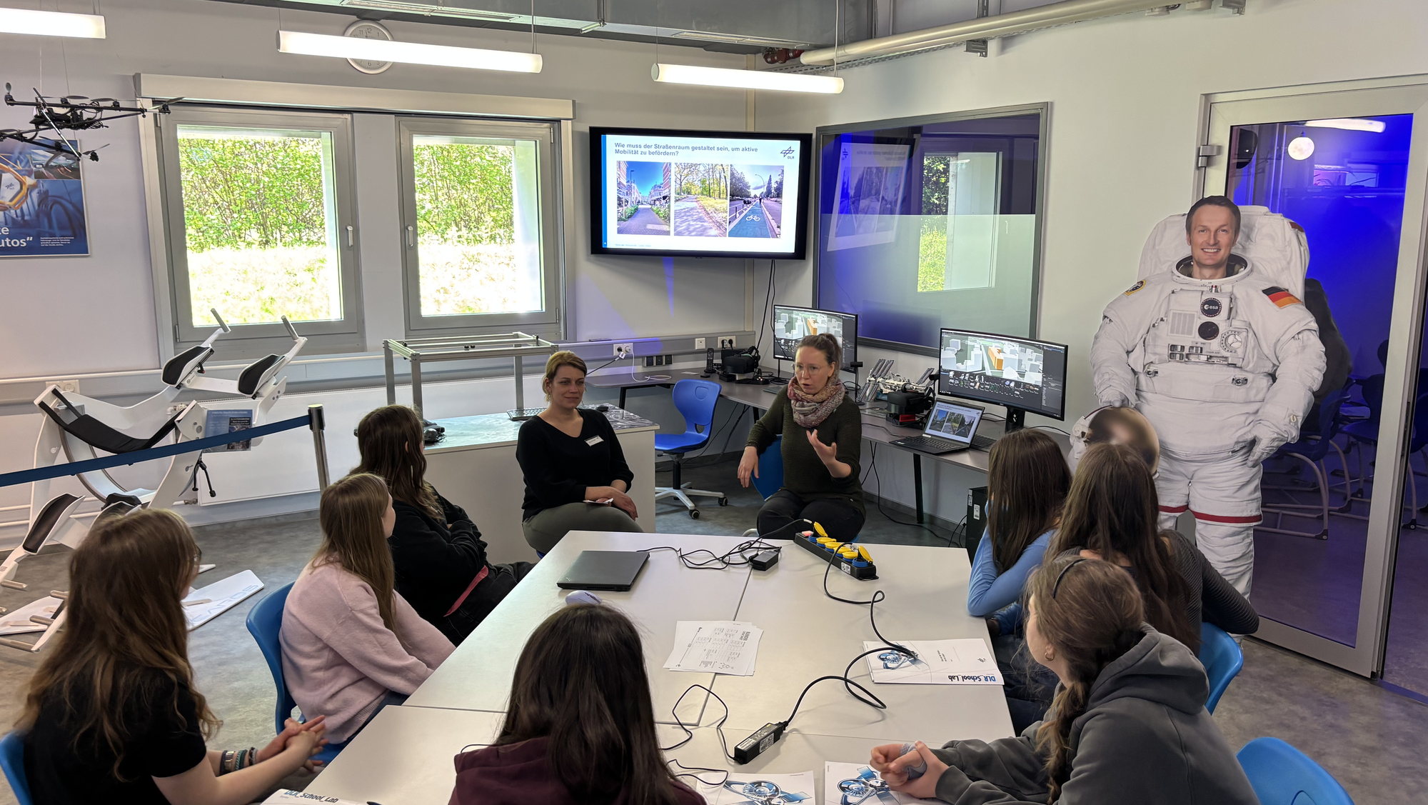 Girls' Day 2026: Um einen Tisch des DLR_School_Lab in Berlin-Adlershof sitzen Schülerinnen zusammen mit zwei Mitarbeiterinnen des DLR-Institut für Verkehrsforschung.