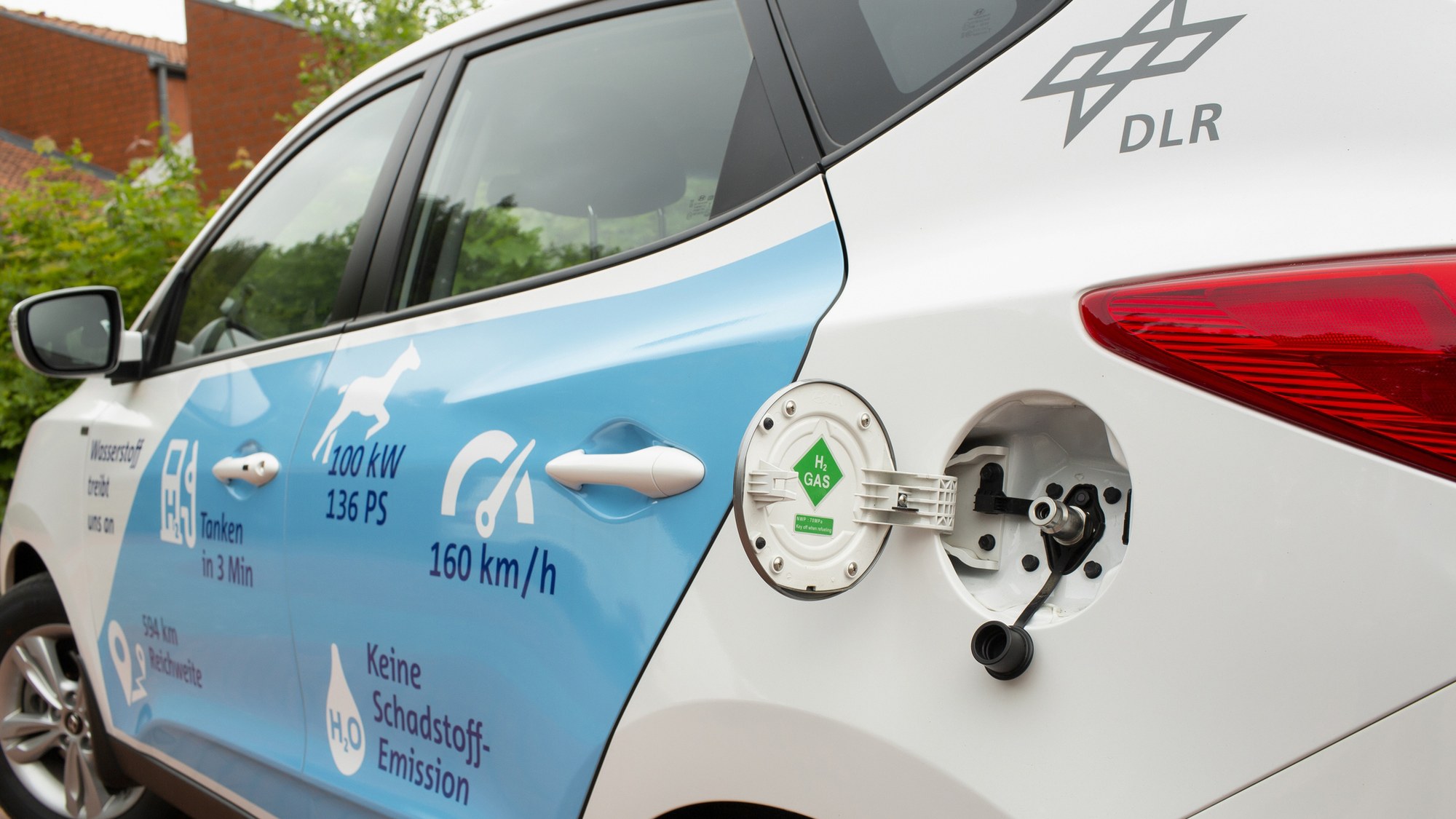 Zu sehen ist ein Wasserstoff-Fahrzeug mit geöffnetem Tankdeckel.