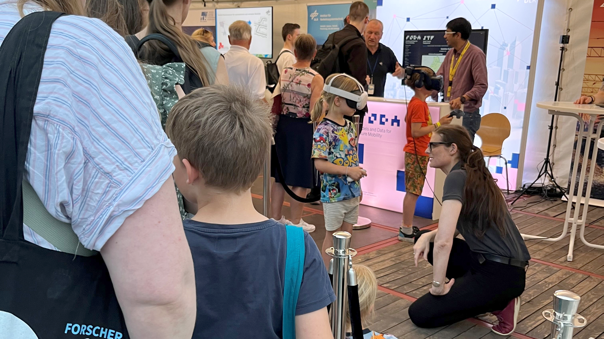 Eine Menschenschlange vor dem Zelt zum DLR Forschungsgebiet des Verkehrs.