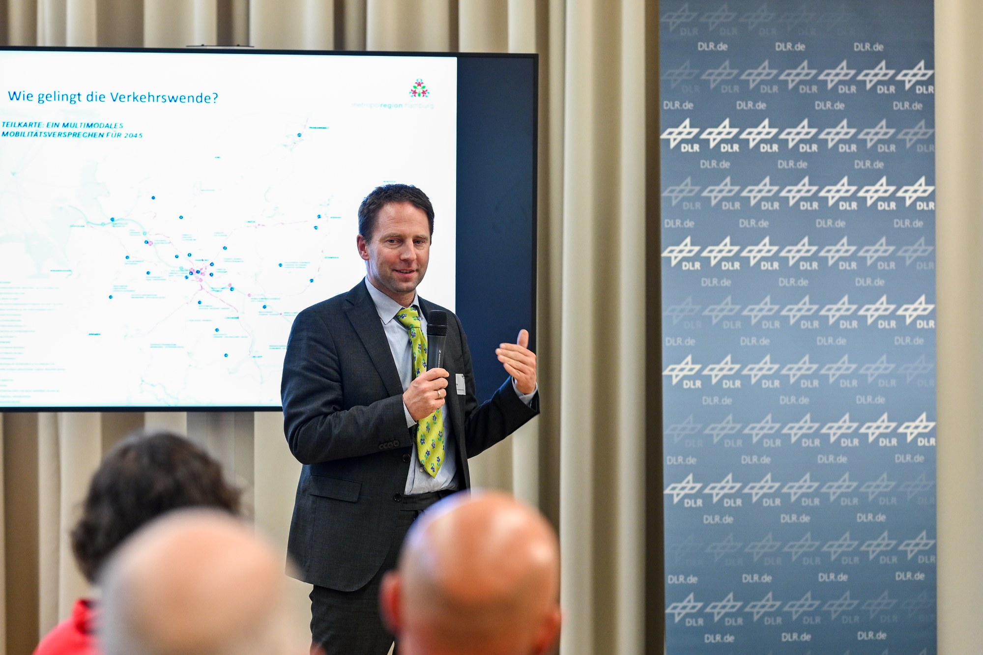 Zu sehen ist Gernot Liedtke vor einem Bildschirm, wie er gerade seinen Vortrag hält