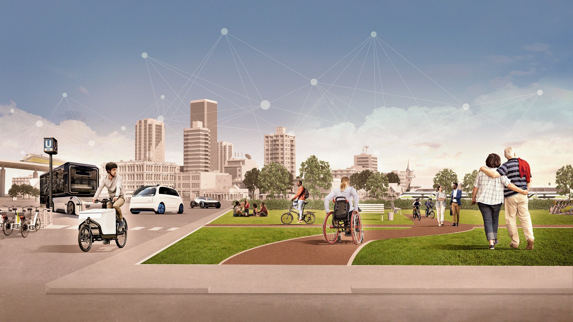 Auf einem kleinen Platz mit großen Wiesen sind verschiedene Personen unterwegs. Eine Rollstuhlfahrerin kann barrierefrei sich zwischen den Pfaden des Platzes und den umliegenden Straßen bewegen. Für Spazierende ist hier genausoviel Platz wie für Radfahrende und die U-Bahn Station ist sicher über einen Zebrastreifen erreichbar. Dort befinden sich auch Fahrradstellplätze und Sharingangebote. Autonom fahrende Autos und Busse, sowie klimaneutrale Fahrzeuge fahren auf der Straße sicher und eine Gruppe aus Freunden wird beim Picknicken nicht durch Abgase oder Lärm gestört. Im Hintergrund zeigen sich Bahnverbindungen, die sowohl außerhalb der Stadt für eine gute Verbindung sorgen, als auch innerhalb.
