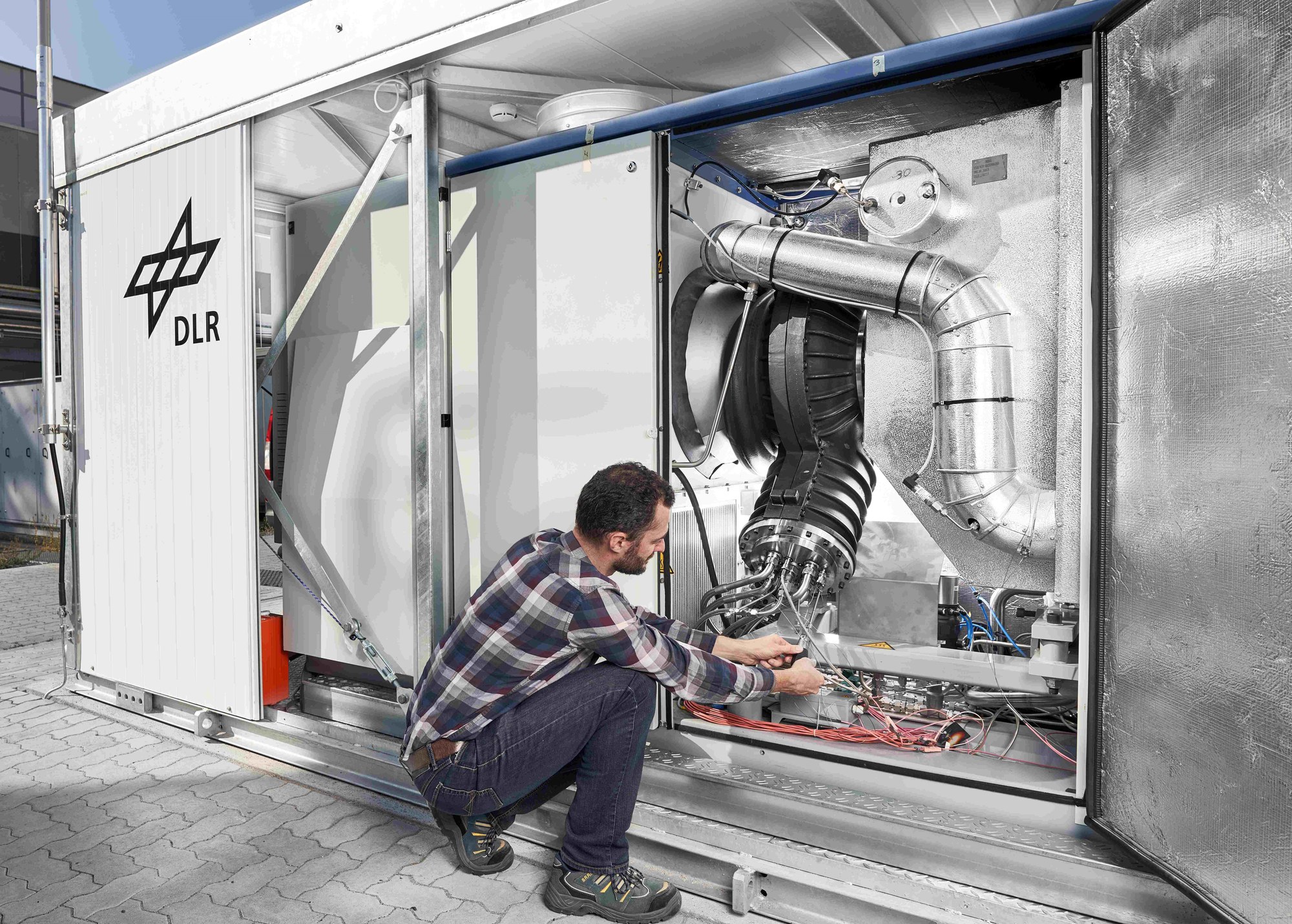 Wissenschaftler arbeitet an der Elektrik einer Mikrogasturbine.