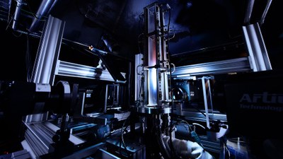 Das Bild zeigt in der Mitte eine große, optisch zugängliche Brennkammer eines atmosphärischen Verbrennungsprüfstands. Rings um die Brennkammer sind mehrere Kamera- und Lasersysteme aufgebaut, die für Messungen genutzt werden können.