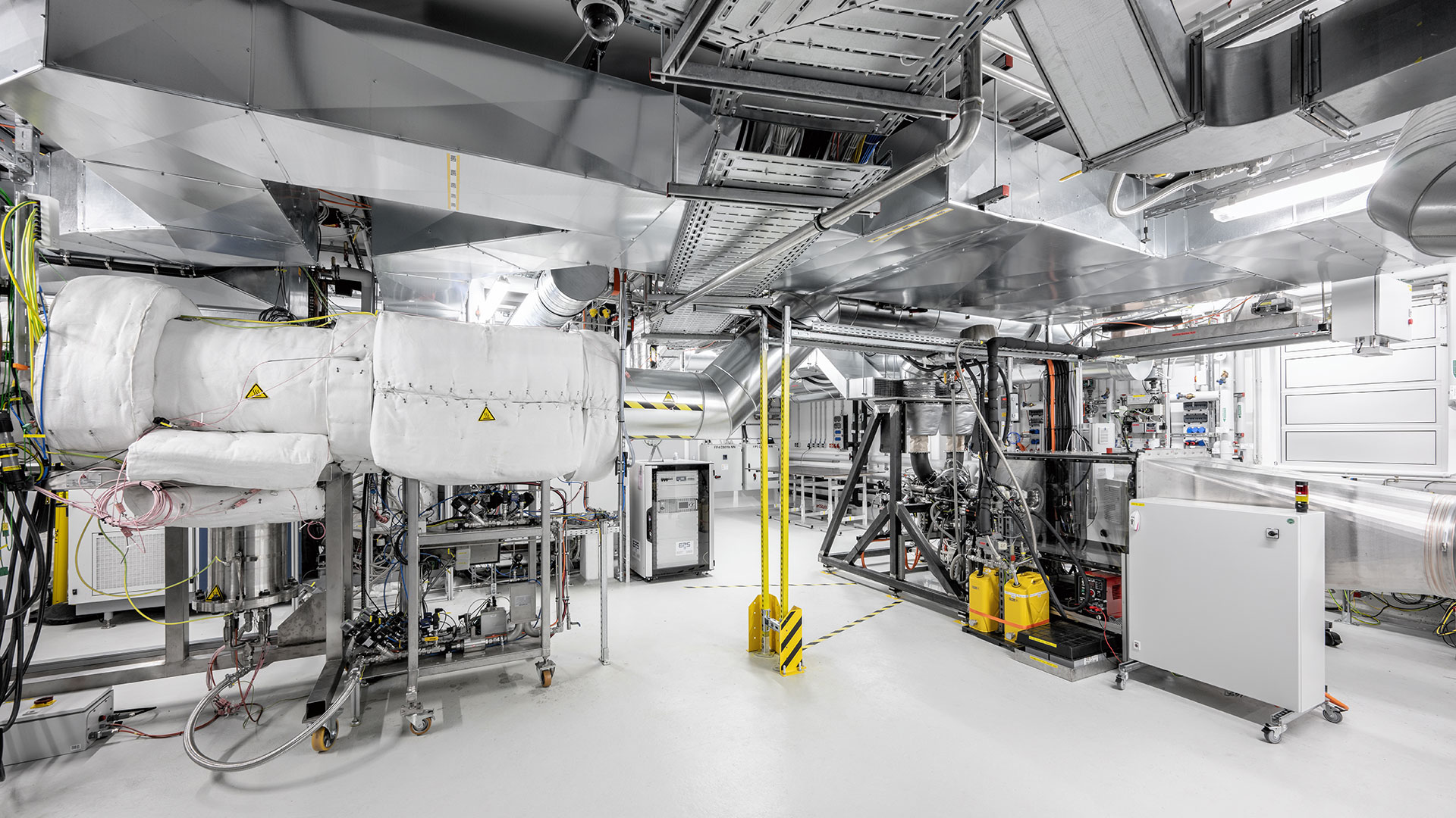 Blick in das Labor Technologie-Plattform Dezentrale Energien (TPDE). Zu sehen sind unterschiedliche Prüfstände und Teile der Laborinfrastruktur.