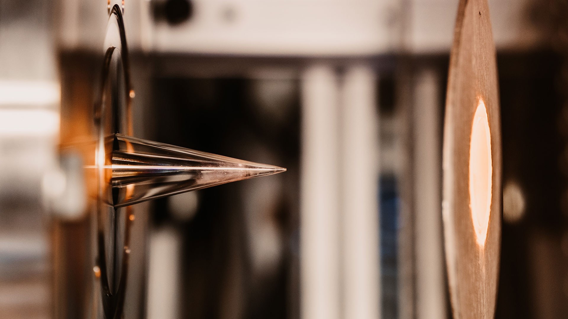 Das Bild zeigt den Strömungsreaktor in Betrieb- links ist die Probenentnahmedüse zu sehen, rechts der Auslass des beheizten Reaktors.