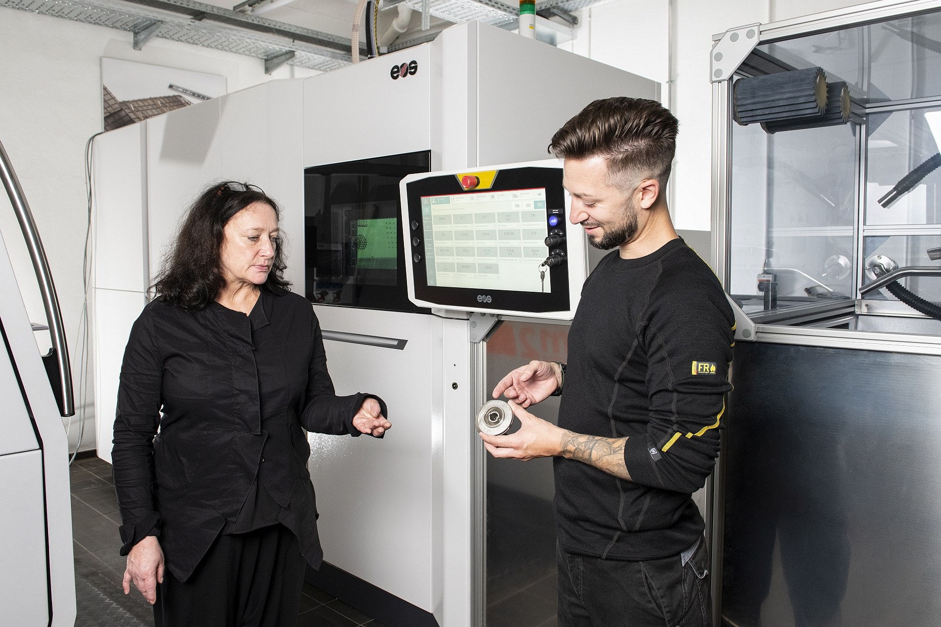 Two scientists test additively manufactured components from new EOS machine