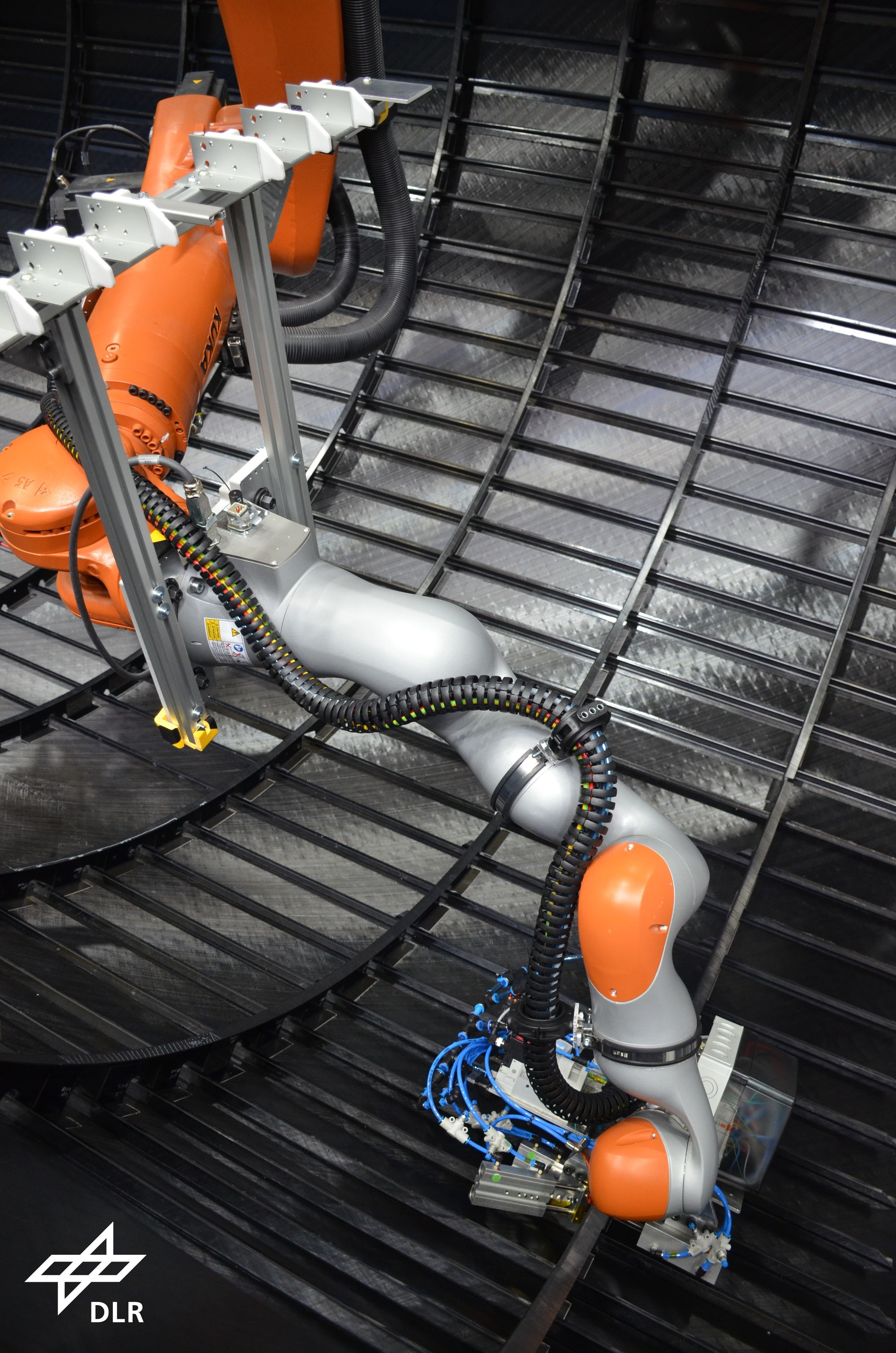 Cleat end effector in cobot-on-robot configuration for resistance welding of cleats to the frames