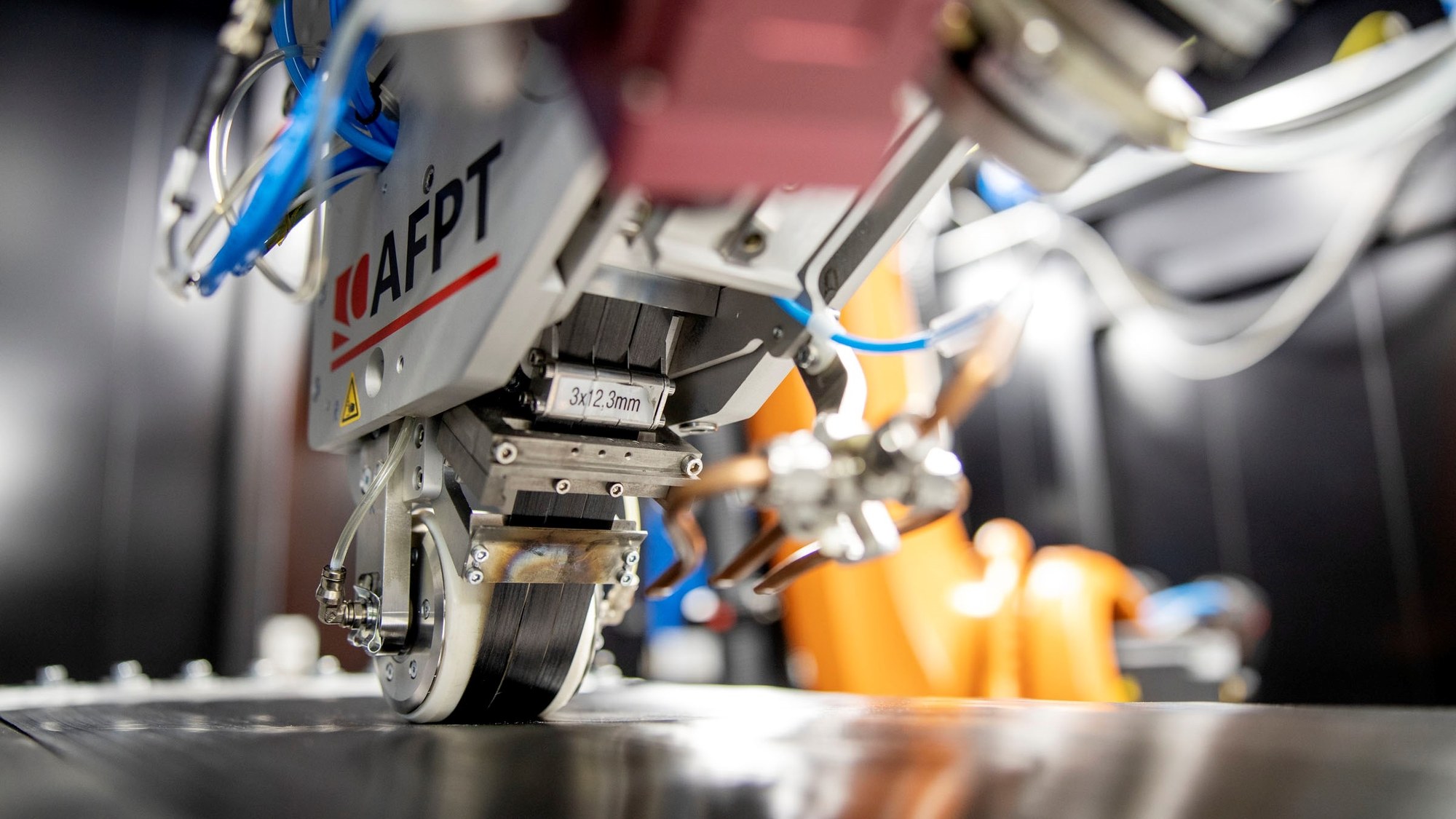 Robotic high-temperature thermoplastic tape laying with an tape laying machine