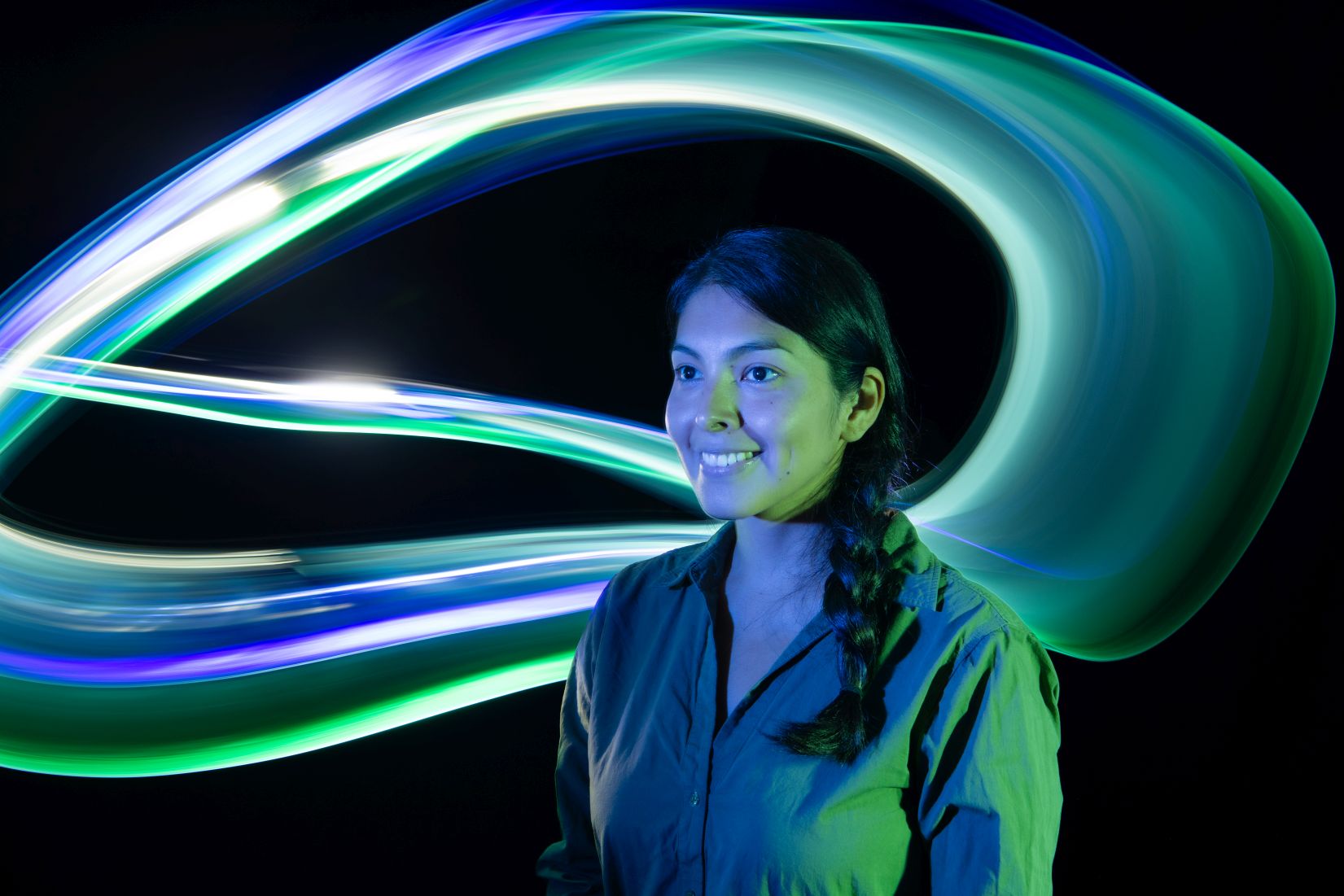 The picture shows Gabriela, a member of staff, and colourful trails of light