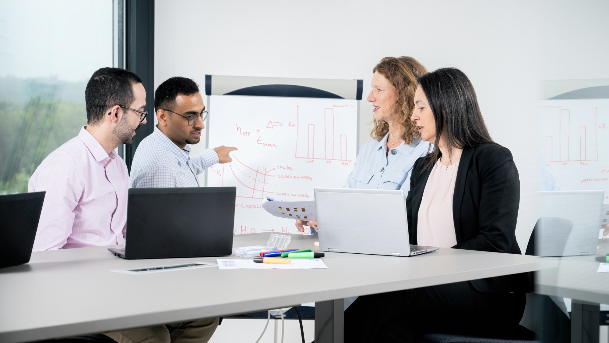 Researchers of the department evaluation of solar production processes working together in a meeting room