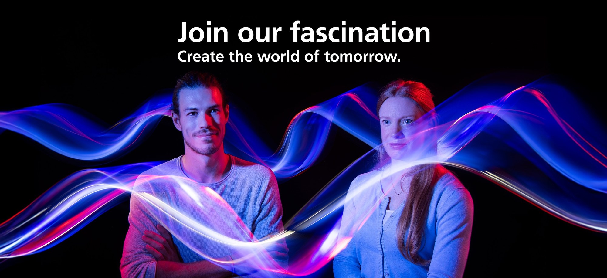 Two DLR employees are pictured. Left: Tobias, right: Celia. They are smiling and surrounded by coloured light beams. Above them is the caption: Join our Fascination Shape the world of tomorrow.