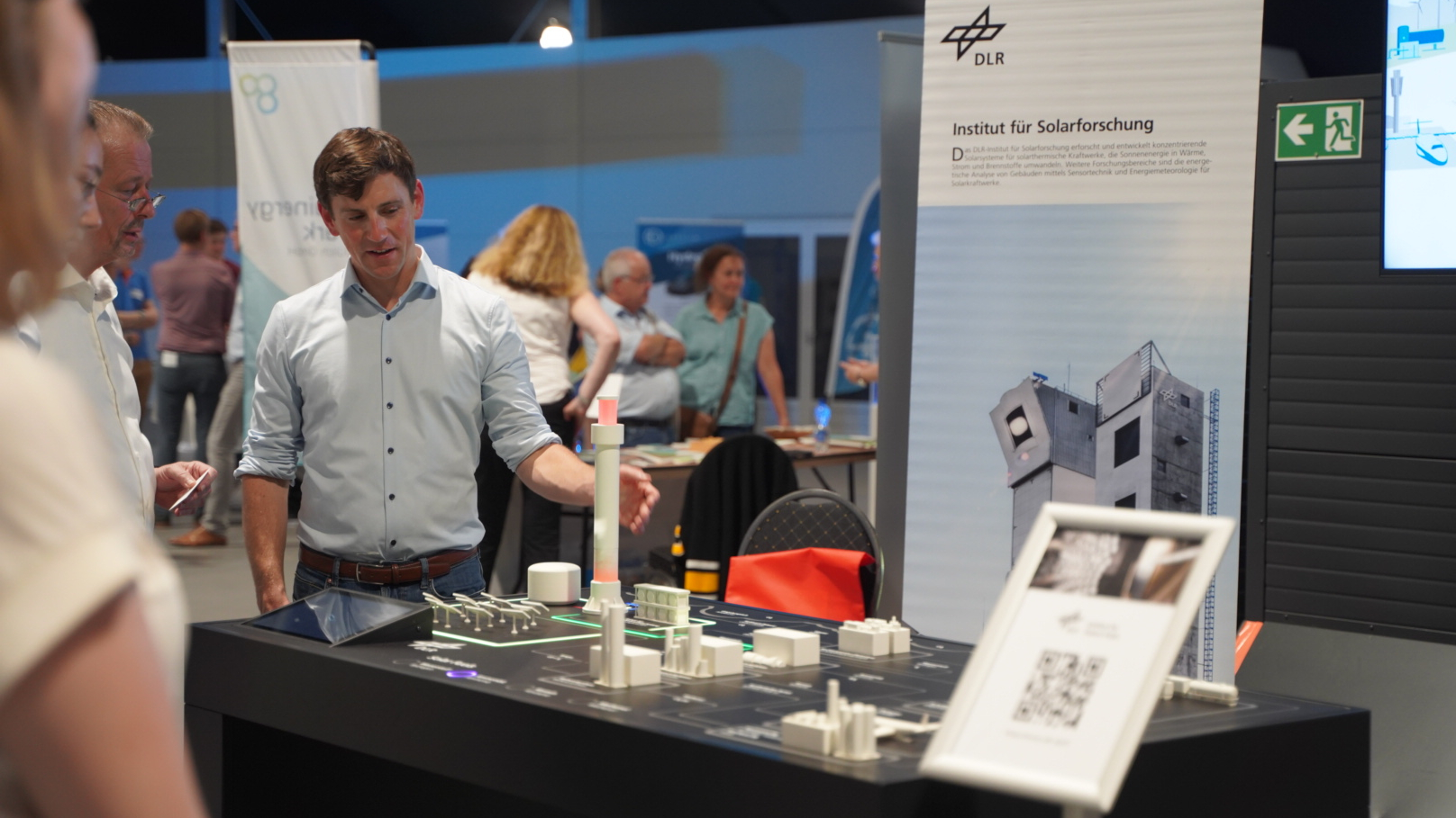 A researcher from the Institute of Future Fuels explains the Solar Fuels exhibit.
