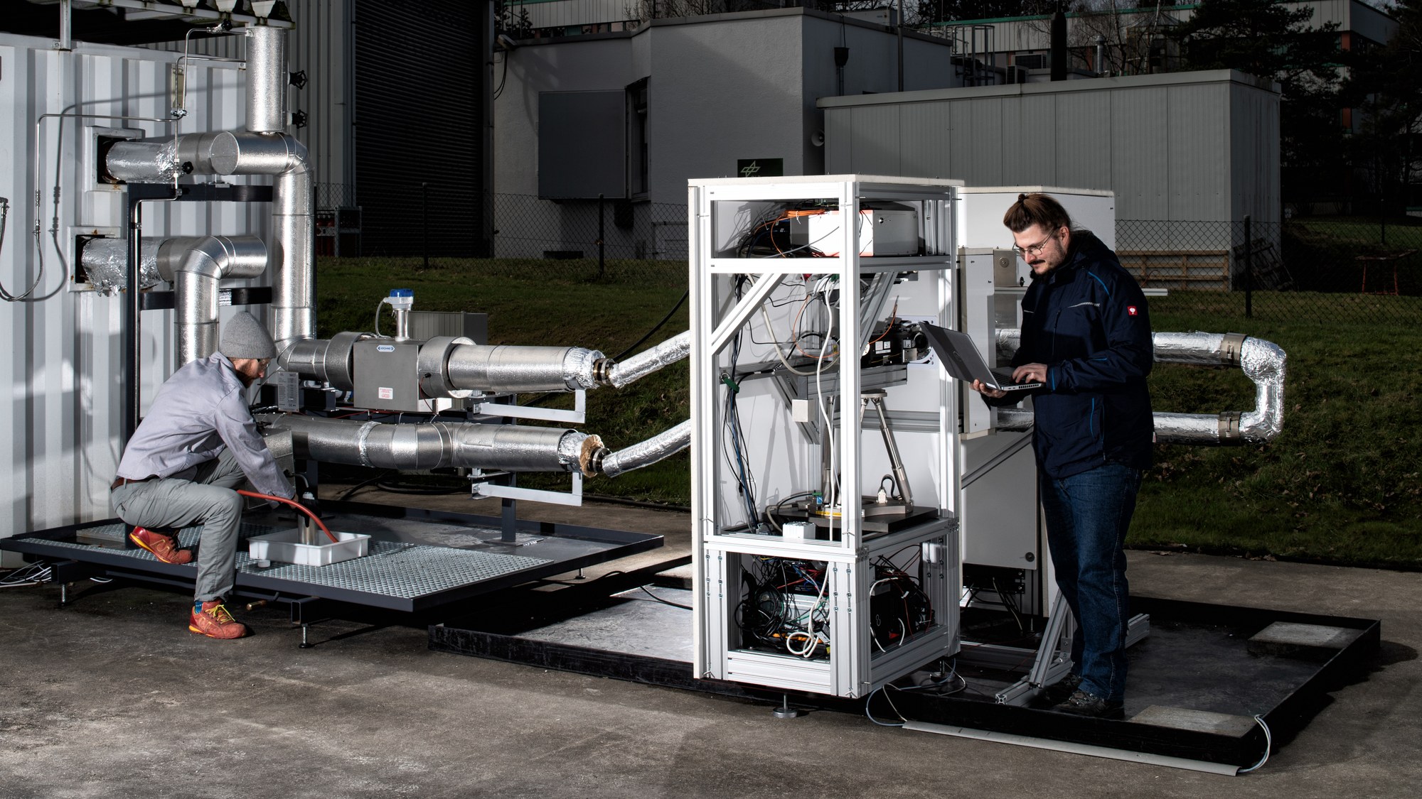 Two researchers are working on the LDV measurement system outside the MOPUW.