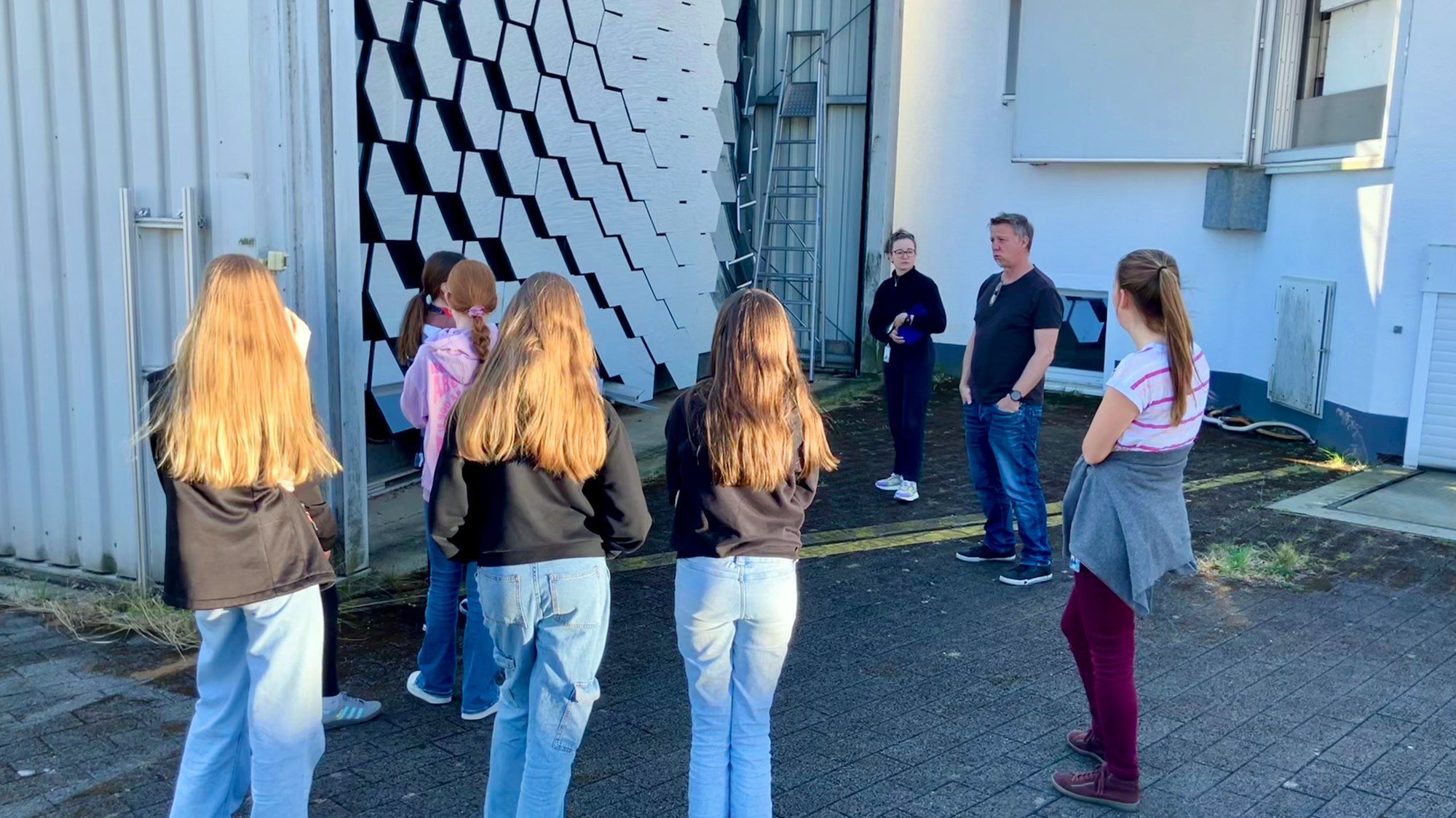 Students and DLR scientists in front of the solar furnace concentrator.